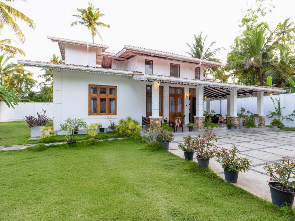 a house with a lawn in front of it at The Calm boutique Villa in Ahangama