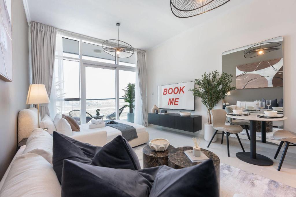 a living room with a couch and a table at Free housekeeping visits during your stay - StayShort - Spacious Carson C Studio in Damac Hills in Dubai Marina