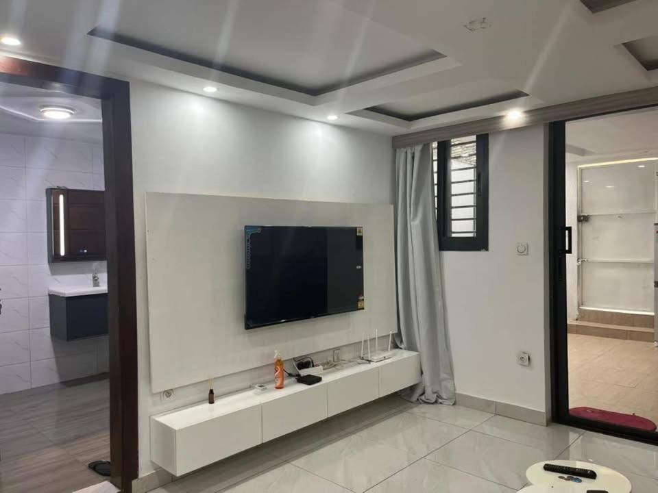 a living room with a television on a white wall at Immeuble cgk in Cocody