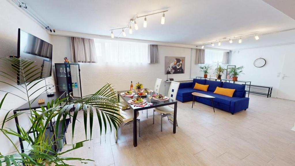 a living room with a table and a blue couch at Fewo Loft Konstanz in Konstanz