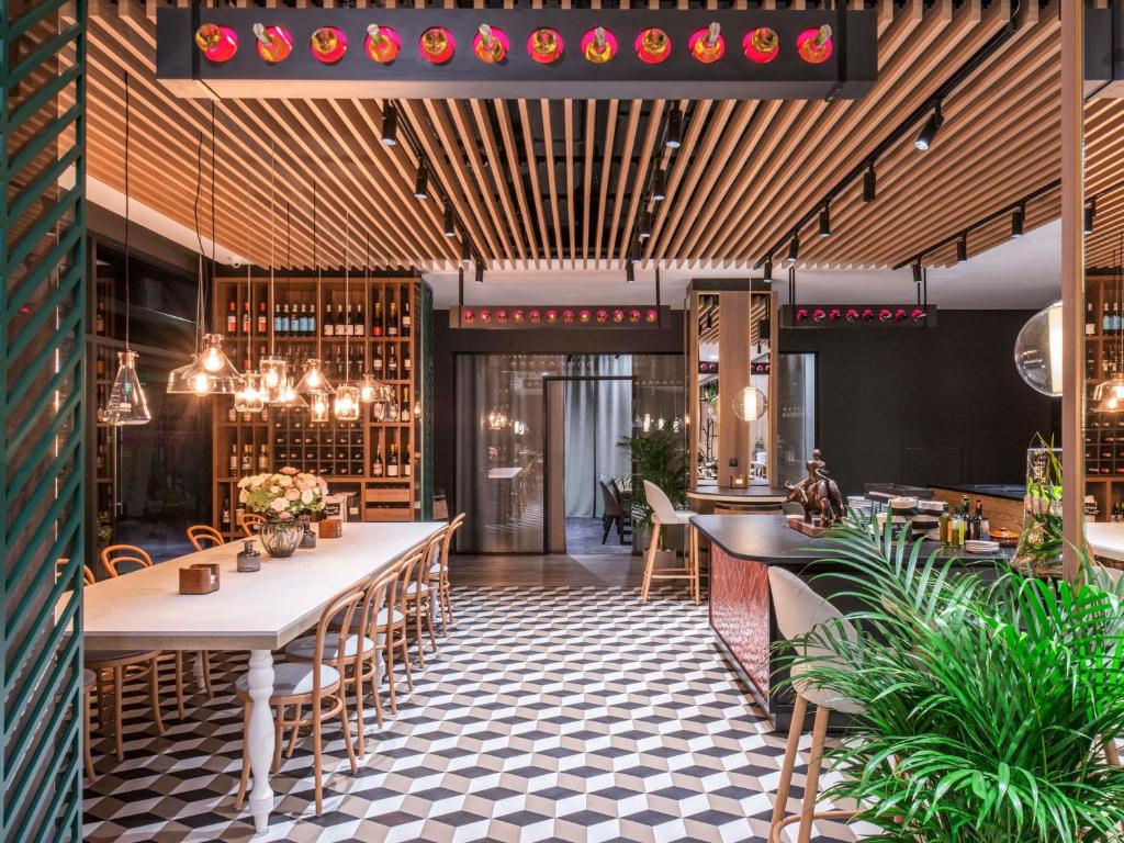 a restaurant with tables and chairs and wine racks at ibis Styles Kraków East in Krakow