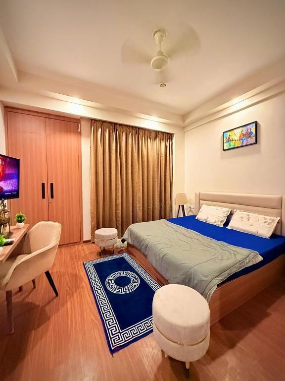 a bedroom with a large bed and a table and chairs at ITC Grand Stay in Greater Noida