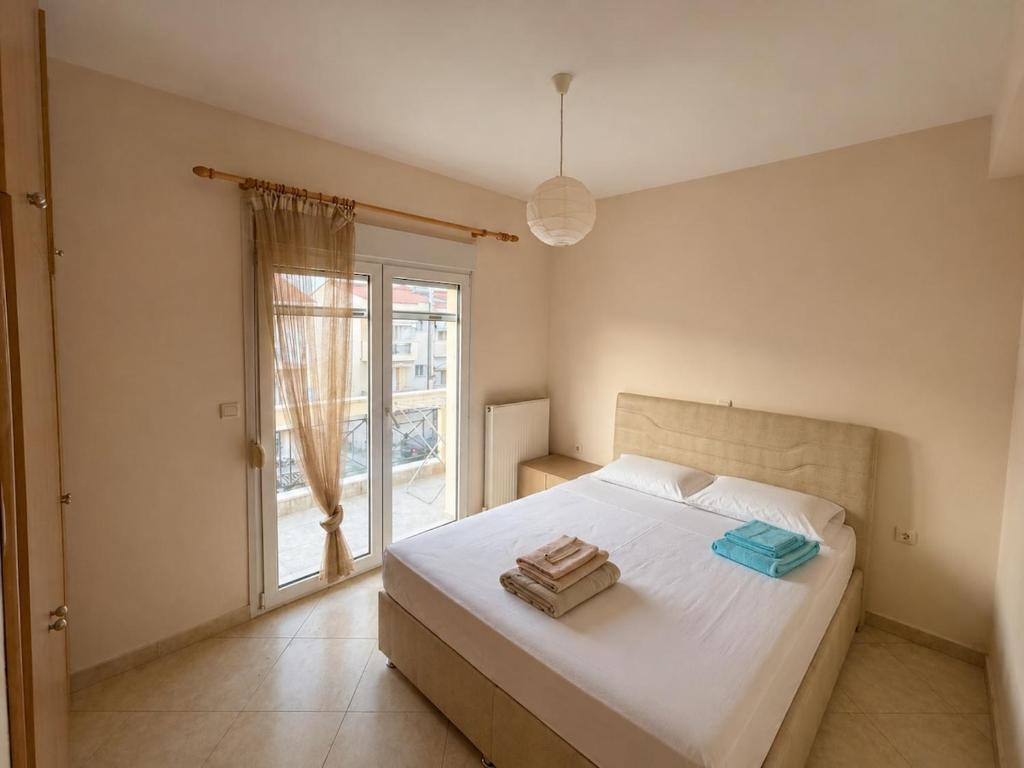 a bedroom with a large white bed with a window at Apartment Deniz in Nea Peramos