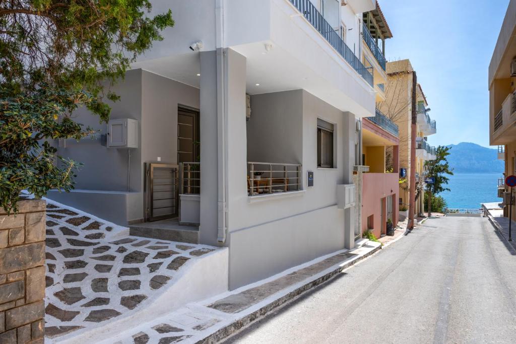 a street with white buildings and the ocean at Kitron Blue Seaside Luxury Apartment in Agios Nikolaos