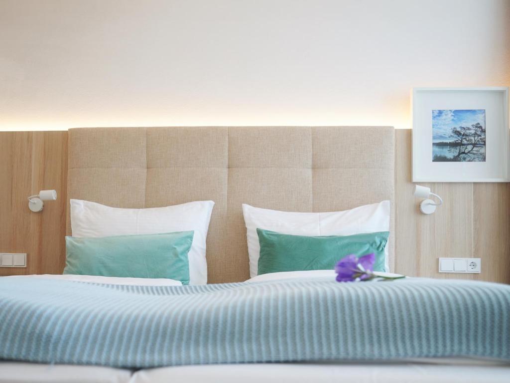 a bedroom with a large bed with blue and white pillows at Boutique Hotel Reschen in Tutzing