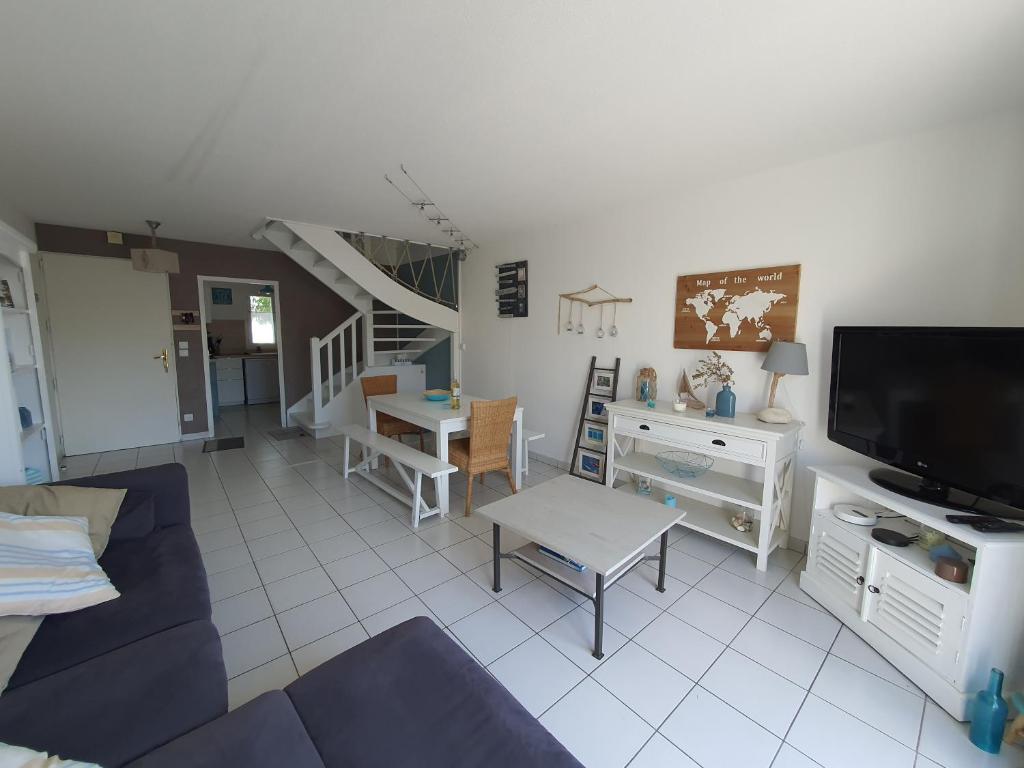 a living room with a blue couch and a tv at Villa Belle Ile in Saint-Pierre-dʼOléron