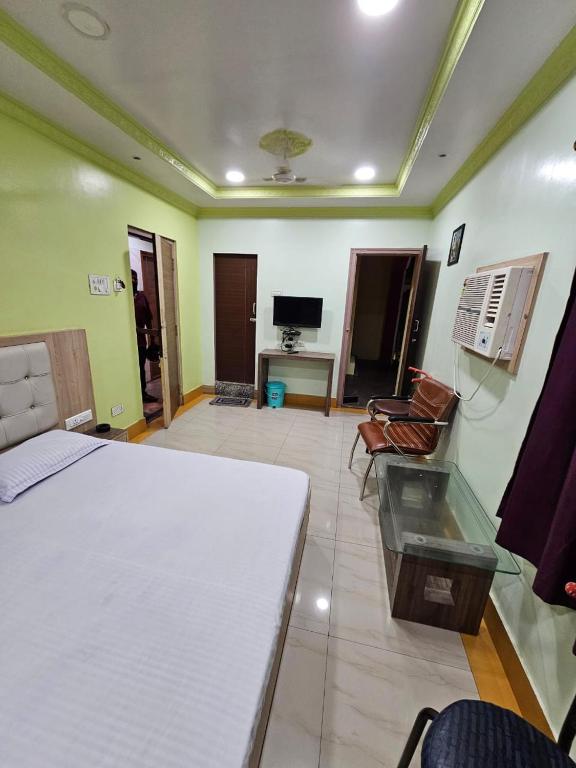 a bedroom with a bed and a living room at Arya Palace in Phulabāni
