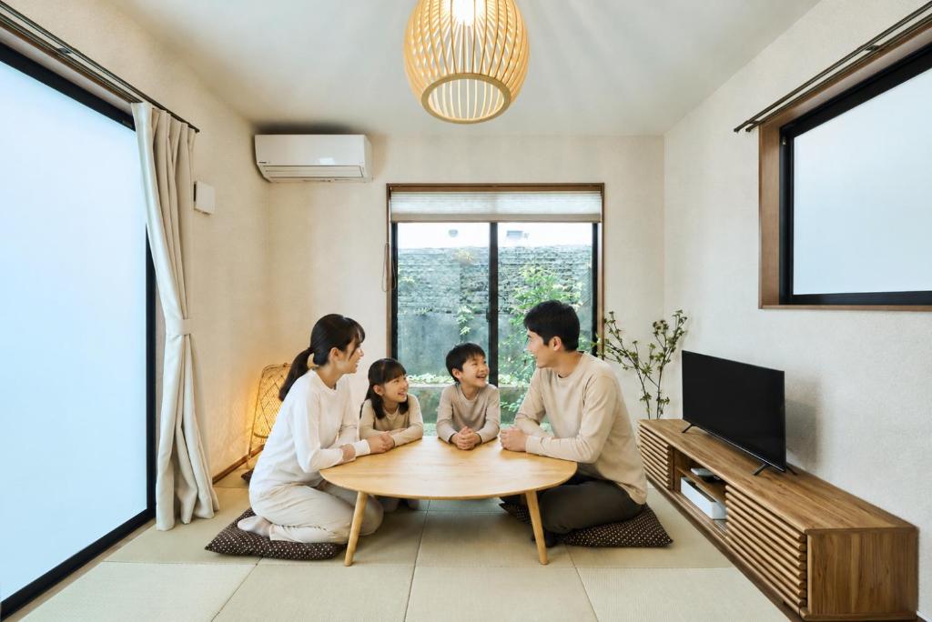 a family sitting around a table in a living room at 平宿新町ホテル in Hanabatachō
