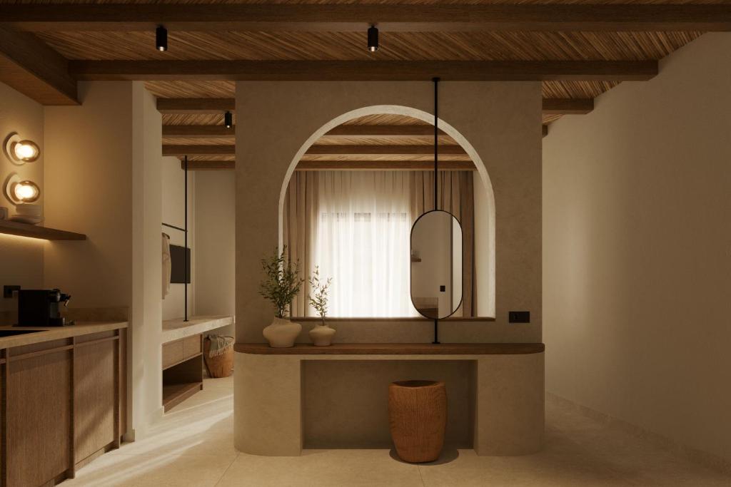 a bathroom with a large mirror and a sink at Salt and stone suites in Vrachonisída touArchangélou