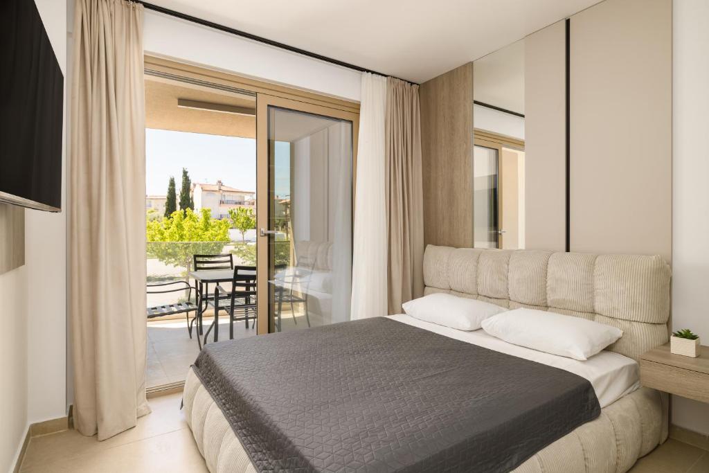 a bedroom with a large bed and a balcony at D & D Apartments in Kassandra