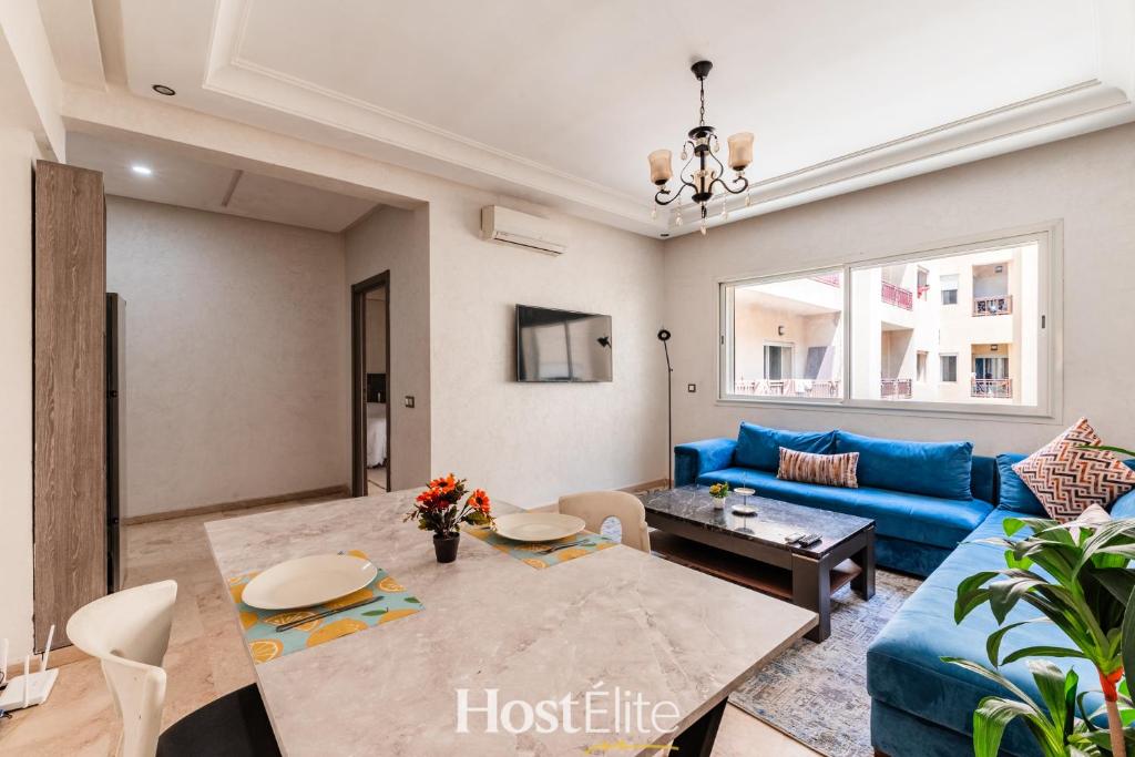 a living room with a blue couch and a table at Appartement Central Park - Clim - 10 min plage in Mohammedia