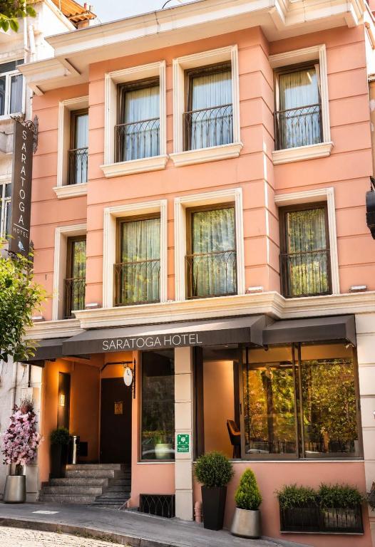 a pink building with a sign for a hotel at Saratoga Hotel Sultanahmet in Istanbul