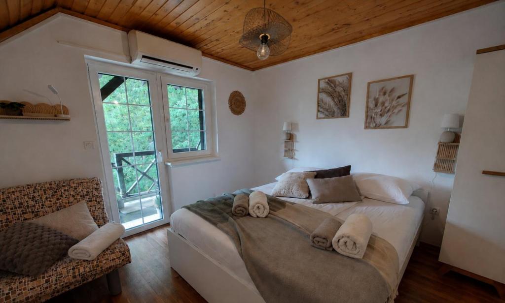 a bedroom with a large bed and a window at Terme Olimia - Apartment Lipa 112 in Podčetrtek