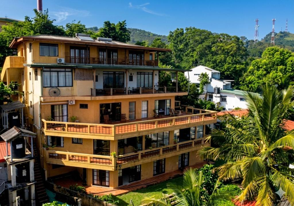 an apartment building with balconies and a palm tree at Kandy Highland Unique Hotel in Kandy