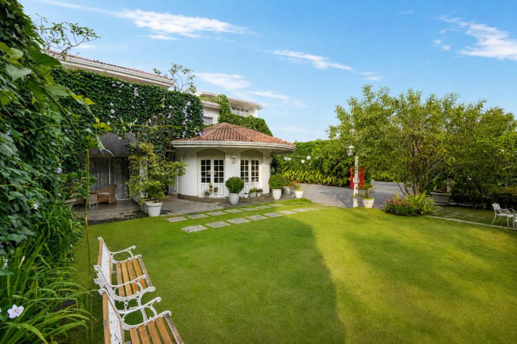 a house with a yard with chairs and trees at Ru Boutique in Kandy