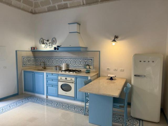 a kitchen with blue cabinets and a stove and a refrigerator at Azzurrina in Marettimo