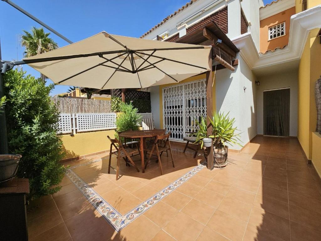 a patio with a table and an umbrella at Casa Althaya in Alcalà de Xivert