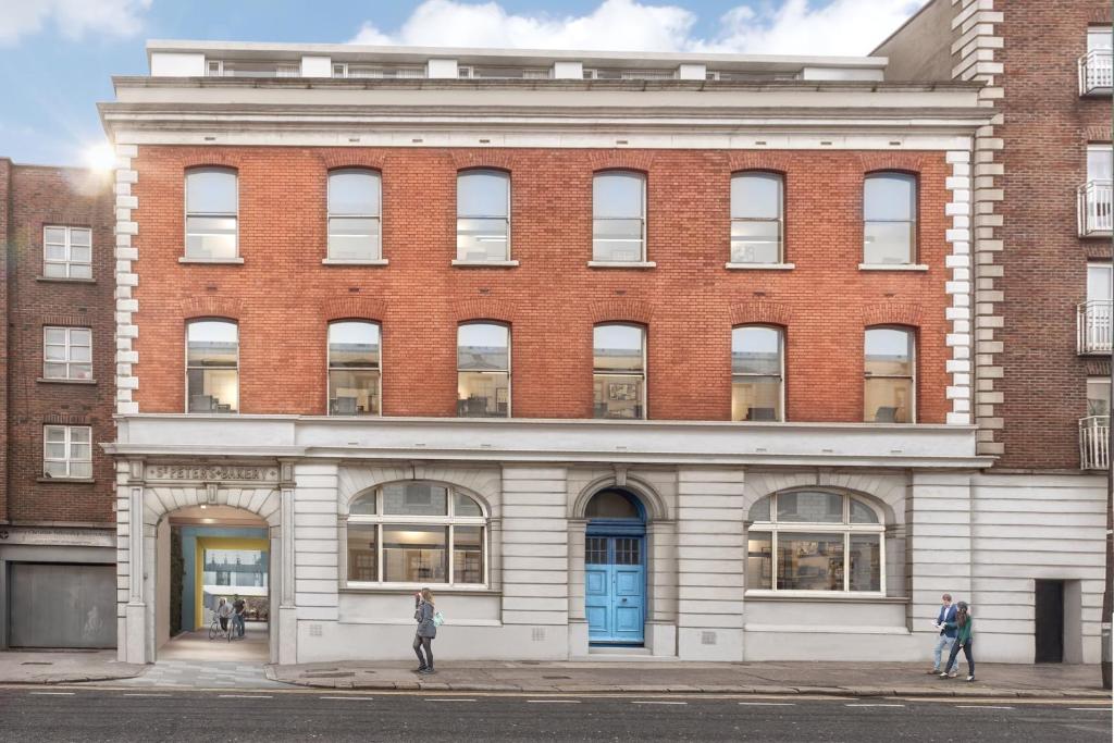 a large brick building with a blue door at The Artisan - City Centre in Dublin