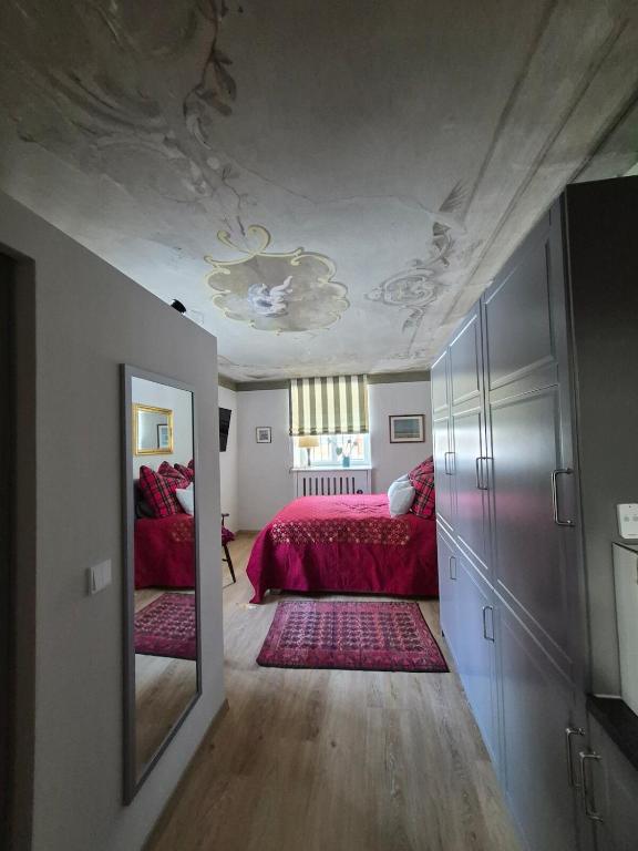 a bedroom with a red bed and a mirror at Entzückendes Studio in historischer Villa in Aschau