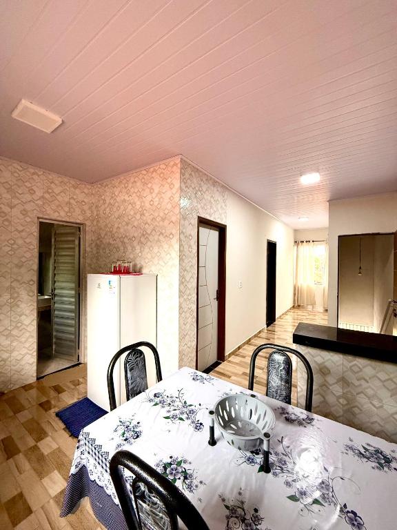 a kitchen with a table with chairs and a refrigerator at Lardunas in Santo Amaro