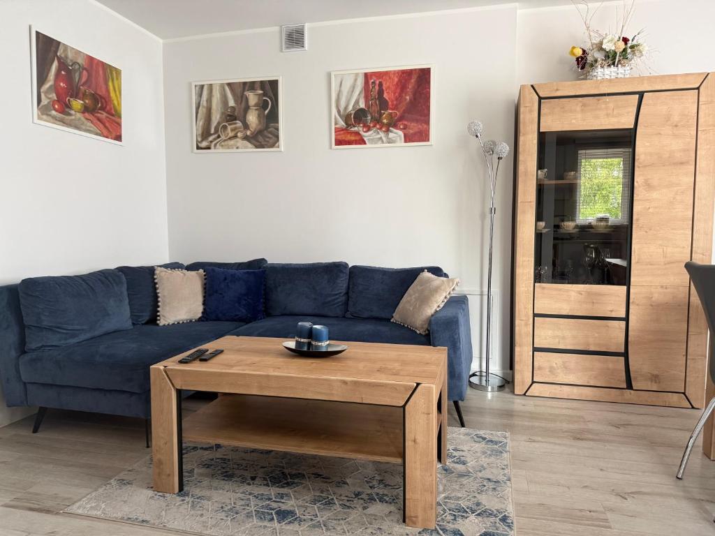 a living room with a blue couch and a coffee table at Mieszkanie - Apartament in Dąbrowa