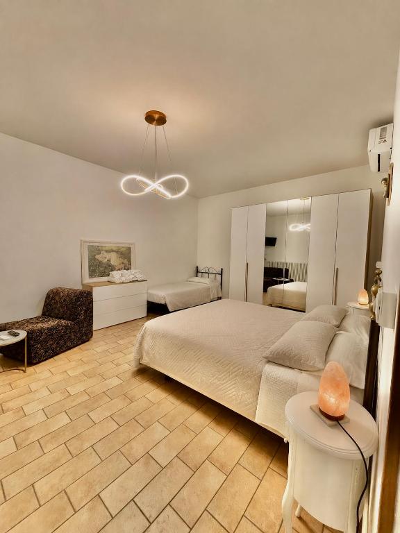 a bedroom with a large bed and a chair at casadiviaappia in Imola
