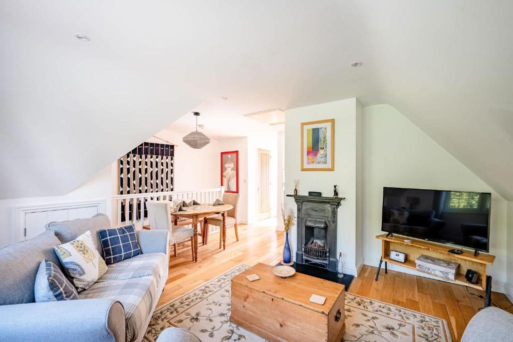 a living room with a couch and a tv at Comfortable Cottage with Decking in Castle Cary in Castle Cary