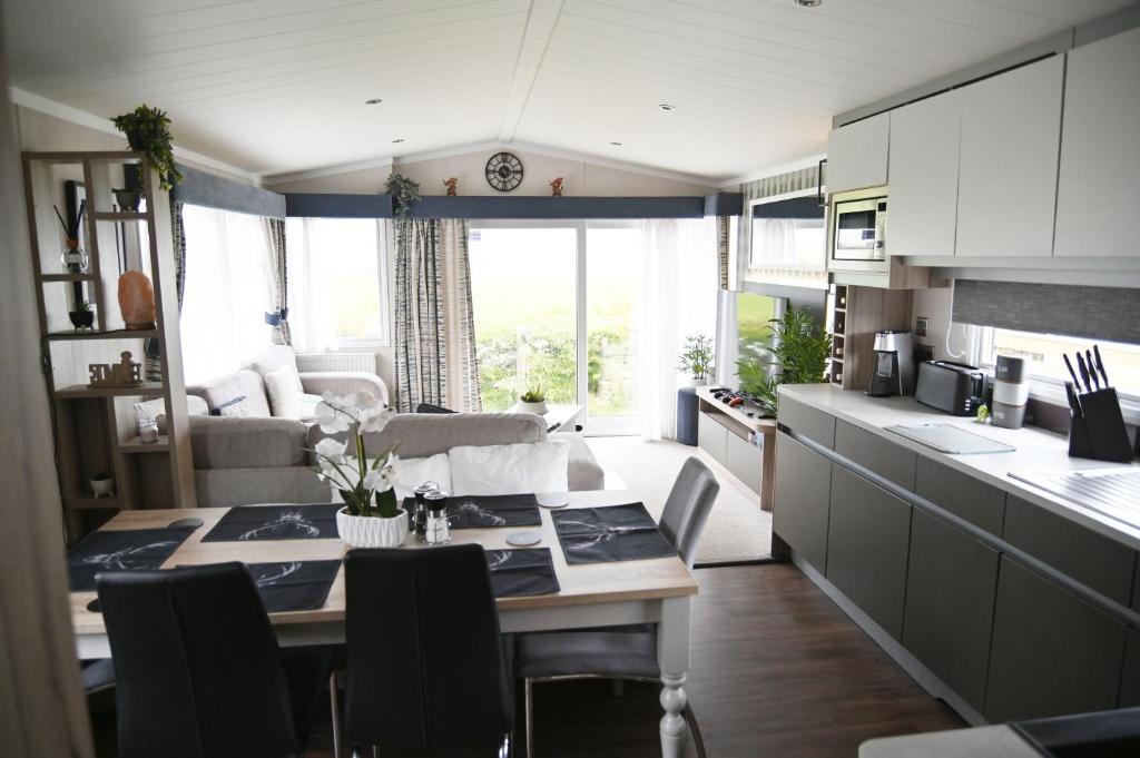 a kitchen and living room with a table in a kitchen at Wild Thistle static Caravan in Kirkcolm
