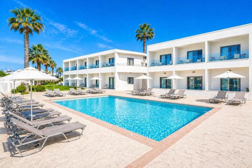 a villa with a swimming pool in front of a building at Vergina Sun in Faliraki