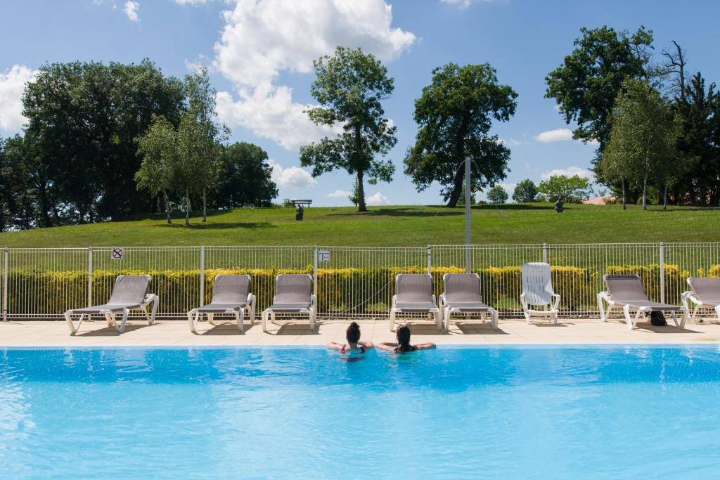 two people in the water in a swimming pool at La Villa 103 in Lombez