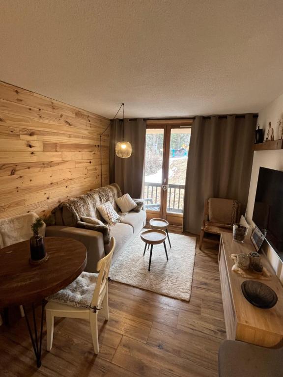 a living room with a couch and a table at Studio Auron 4 couchages in Saint-Étienne-de-Tinée