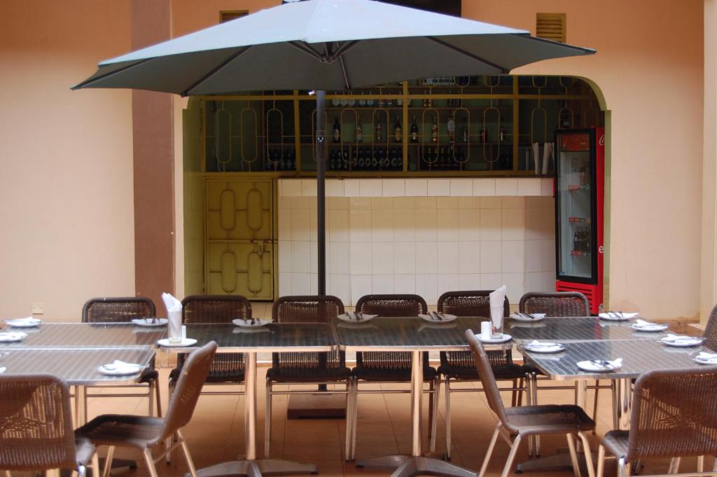a large table with chairs and an umbrella at Sky Hotels Emali in Mwanda