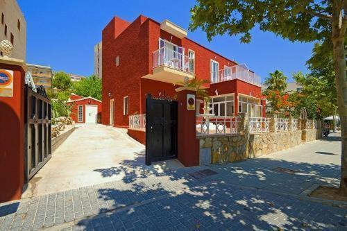 a red brick building with a black door on a street at Villa Palmer in Paguera