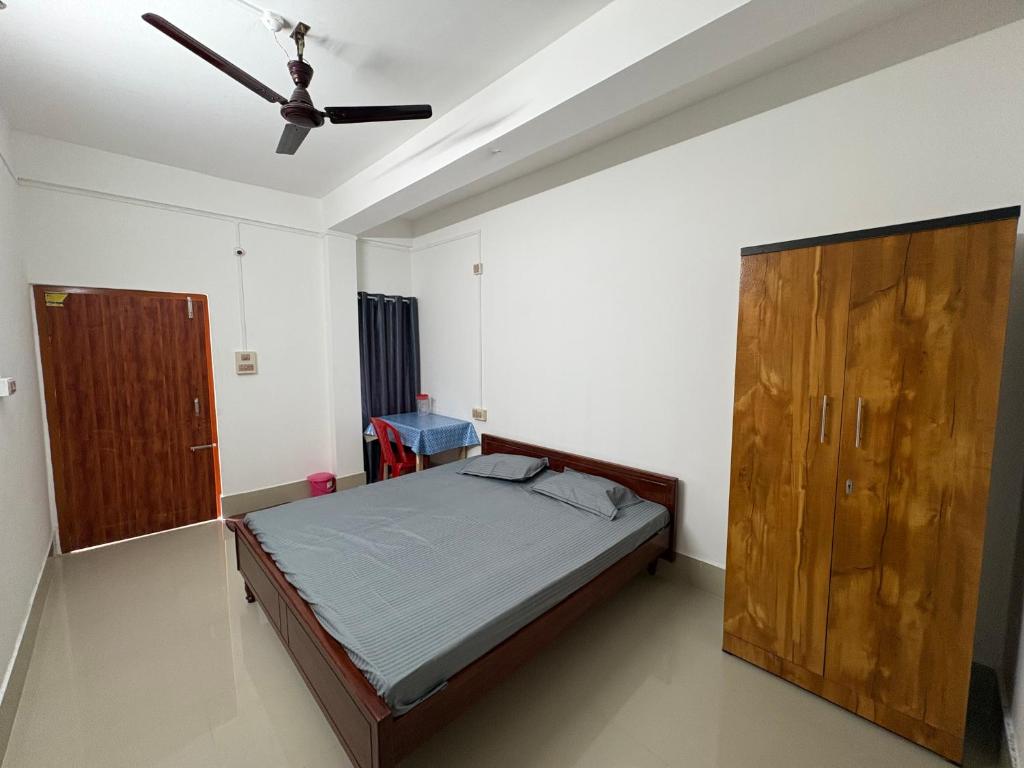 a bedroom with a bed and a ceiling fan at Mousumi Lodge in Tezpur