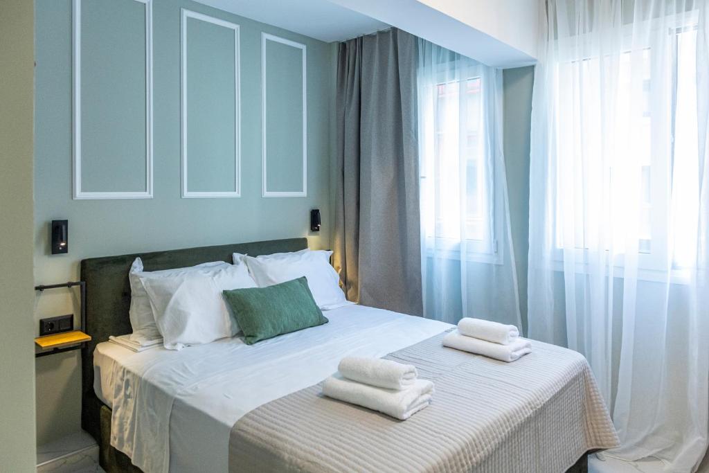 a bedroom with a bed with towels on it at Ernest Suites Monastiraki in Athens
