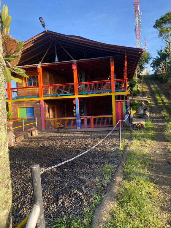 a colorful house with a fence in front of it at Cabaña la Divisa in Jardin