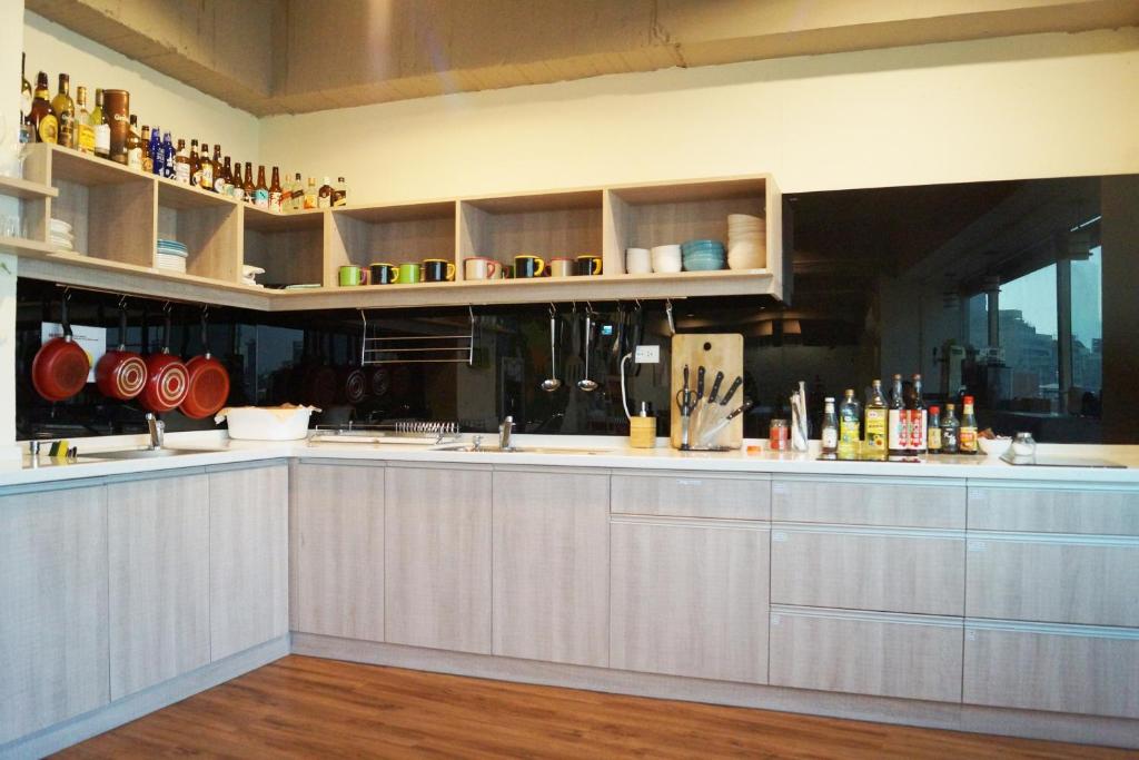 a kitchen with white cabinets and a counter top at Trip GG Hostel in Kaohsiung