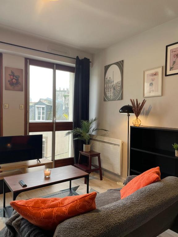 a living room with a couch and a table at Le Cocon Cornouaillais, hyper centre, parking pv in Quimper