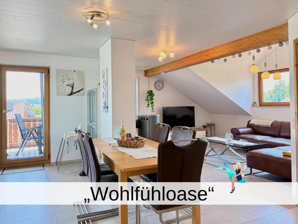 a dining room and living room with a table and chairs at Ferienwohnung Wohlfühloase - gemütliche Familienunterkunft in ruhiger Lage in Achberg