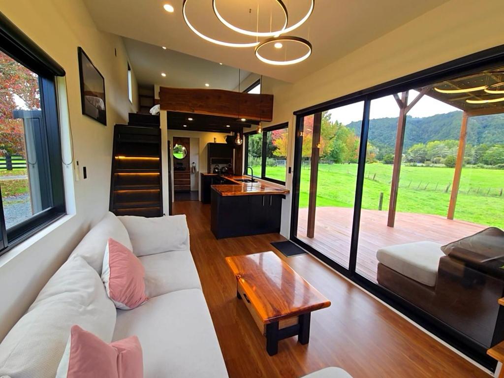 a living room with a white couch and a table at Luxe Tiny Home in Whangarei