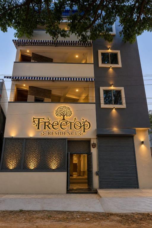 a building with a sign on the side of it at Tree Top Residency in Mysore