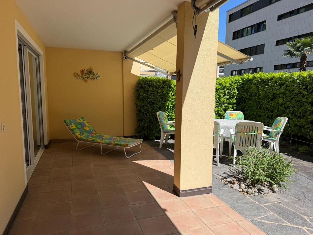 a patio with a table and chairs on a patio at Residenza delle Fonti by HolAp SA in Minusio