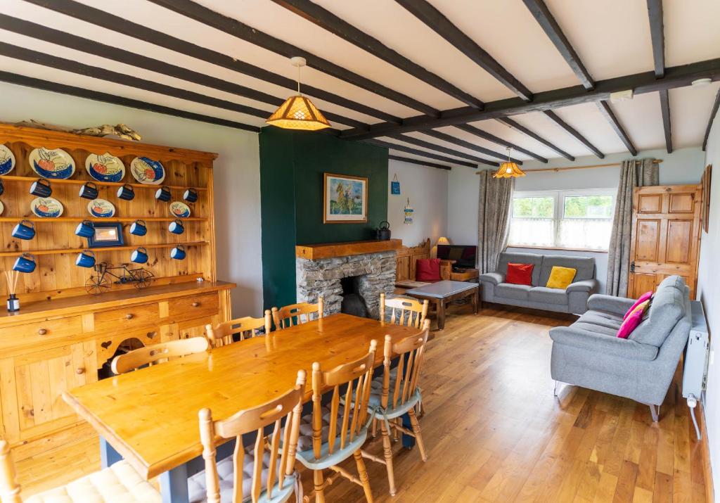 a dining room with a table and a fireplace at Blasket Cottage - Portmagee in Lateeve
