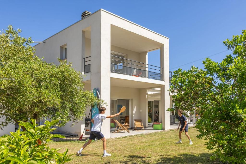 three men playing frisbee in front of a house at Villa Santa Mara Poggio in Santa-Maria-Poggio