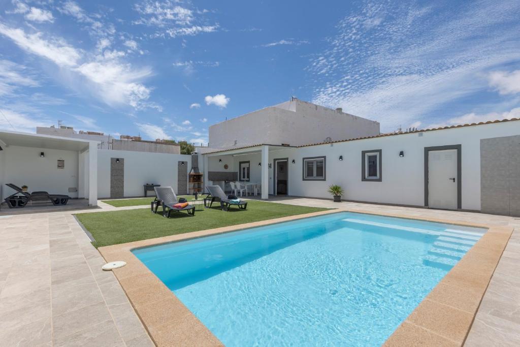 a swimming pool in front of a house at Casa Muley in El Matorral