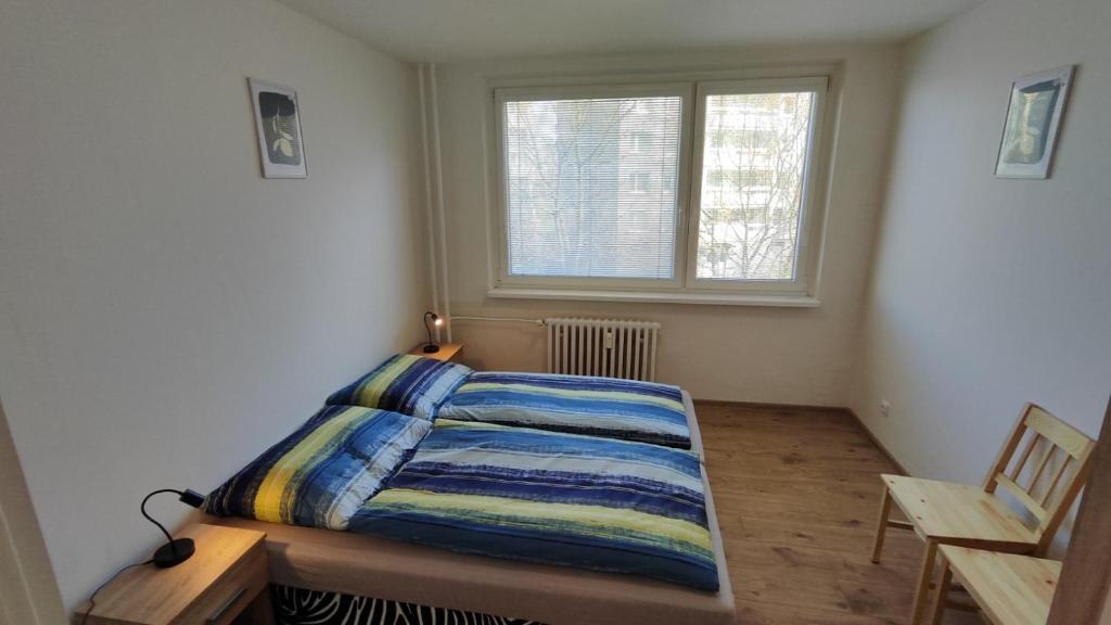 a small bedroom with a bed and a window at Apartmán pro 4 osoby, Most M1 in Most