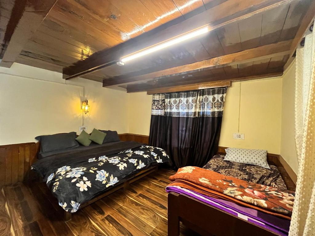 a bedroom with two beds in a room at Negi Wooden House in Manāli