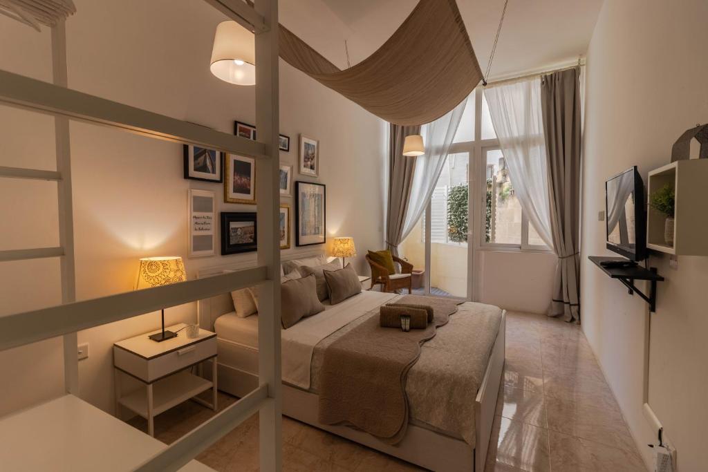 a bedroom with a large bed and a large window at Sea Steps Marsalforn in Marsalforn
