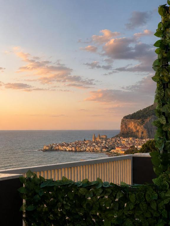 a view of a city and the ocean at sunset at Infinity Blue in Cefalù