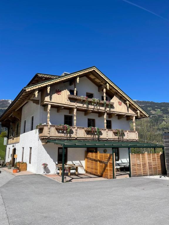 a large white building with a balcony at Der Waidachhof Zillertal in Hainzenberg